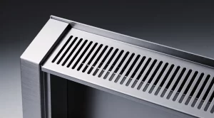 A sleek, silver-grey sheet metal fireplace housing displayed in a modern living space, highlighting precise craftsmanship and industrial aesthetics in 169 landscape orientation.