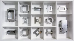 Nine-grid storage box layout showcasing diverse stamped metal components with professional overhead lighting