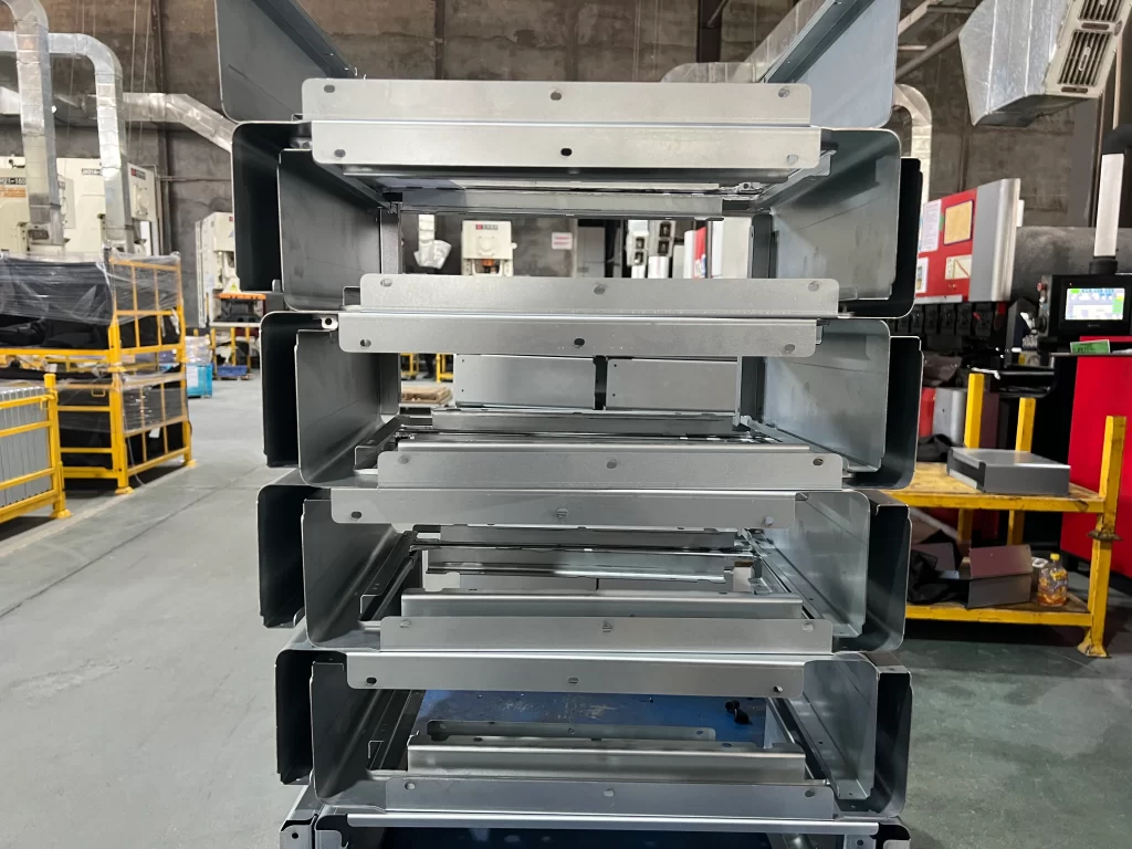 Stacked semi-finished metal drawer components after sheet metal bending in a factory workshop