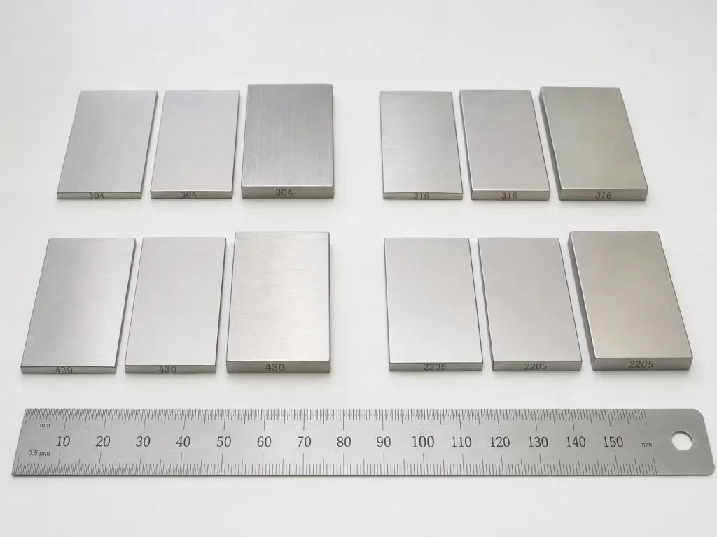 Stainless steel sample pieces in grades 304, 316, 430, and 2205 with varying thicknesses and surface finishes.